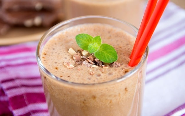 Milkshake (chokolate and banana smothie) in glass with mint and nuts, homemade dairy breakfast horizontal close up